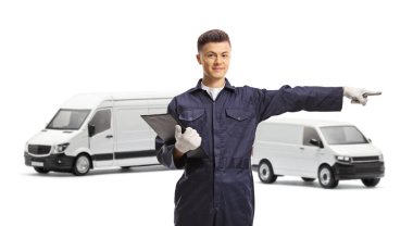 Minibüsleri olan araba tamircisi pano tutuyor ve beyaz arka planda izole edilmiş tarafı işaret ediyor.