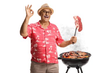 Beyaz arka planda izole edilmiş çatallı çiğ biftekli mutlu olgun bir adam.