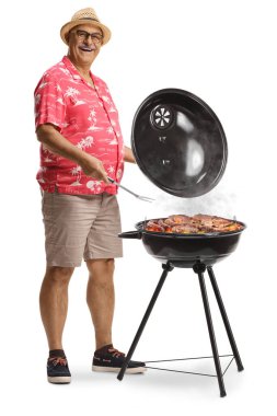 Beyaz arka planda ızgara yapan olgun bir adam.