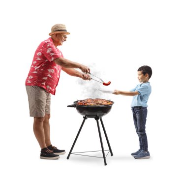 Olgun bir adam beyaz arka planda izole edilmiş bir çocuğa ızgara bbq sosisi veriyor.