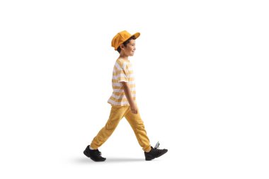 Sarı şapkalı bir çocuğun beyaz arka grubunda tek başına yürüdüğünü gösteren uzun bir profil fotoğrafı.