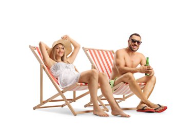 Beyaz arka planda izole edilmiş plaj sandalyelerinde güneşlenen genç çift.