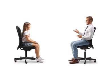 Sandalyede oturan ve beyaz arka planda izole edilmiş küçük bir kızla konuşan bir adam.