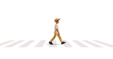 Zebra geçidinde tek başına yürüyen beyaz bir çocuğun tam boy profil çekimi.