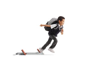 Okul üniformalı bir çocuğun beyaz arka planda izole edilmiş başlangıç bloklarından kaçarken tam boy profil fotoğrafı.