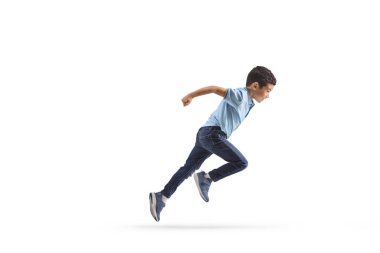 Beyaz arka planda hızlı koşan kotlu bir çocuğun tam boy profil fotoğrafı.