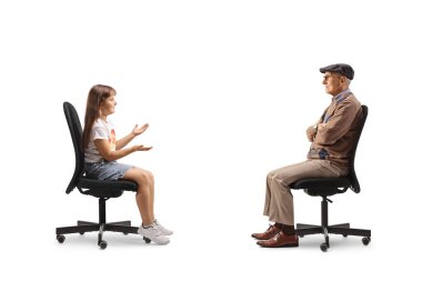 Çocuk bir sandalyede oturuyor ve beyaz arka planda izole edilmiş yaşlı bir adamla konuşuyor.