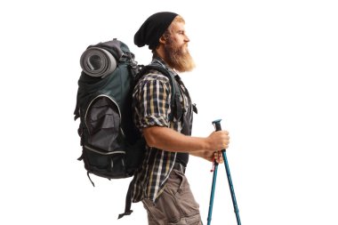 Sırt çantası ve yürüyüş direkleri olan sakallı bir adamın profil fotoğrafı beyaz arka planda izole bir şekilde yürüyor.