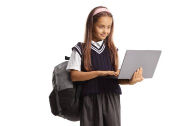 Okul üniformalı bir kız dizüstü bilgisayar tutuyor ve beyaz arka planda izole edilmiş ekrana bakıyor.