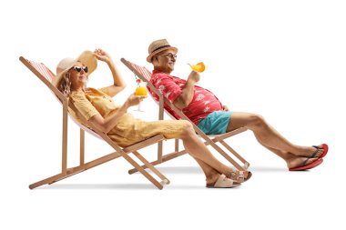 Olgun çift plaj sandalyelerinde eğleniyor ve beyaz arka planda izole edilmiş kokteyller içiyorlar.