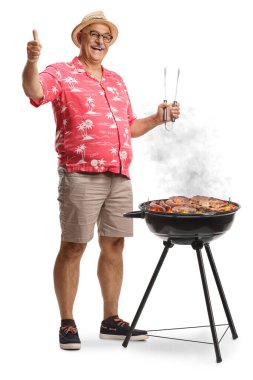 Elinde ızgara cımbızı ve beyaz arka planda izole edilmiş el kol hareketi yapan olgun bir adam.