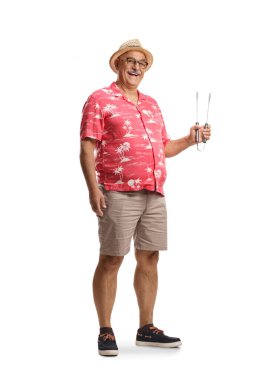 Beyaz arka planda ızgara cımbızı tutan gülümseyen olgun bir adam.