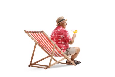 Plaj sandalyesinde oturan ve beyaz arka planda izole edilmiş bir kokteyl tutan bir adam.