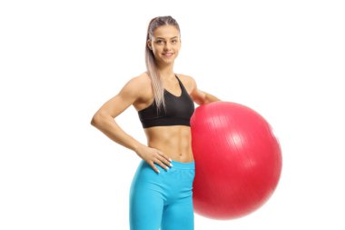 Beyaz arka planda izole edilmiş bir egzersiz topuyla duran genç bayan. 