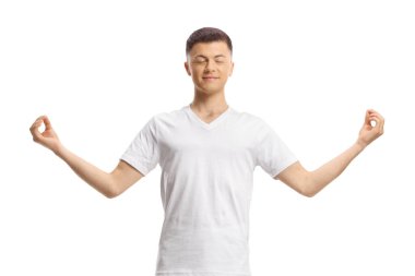 Beyaz elbiseli genç adam ayakta duruyor ve meditasyon yapıyor.