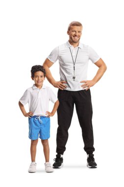 Mavi şortlu ve beyaz tişörtlü bir çocuğun beyaz arka planda izole edilmiş bir spor koçuyla poz verişi.