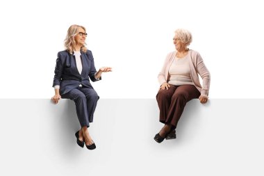 Olgun ve yaşlı bir kadın bir panelde oturuyor ve beyaz arka planda izole edilmiş bir konuşma yapıyor.