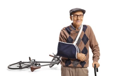 Kırık kollu yaşlı bir adam beyaz arka planda izole edilmiş bisiklet kazasından sonra iyileşiyor.