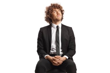 Genç profesyonel bir adam beyaz arka planda izole bir şekilde oturuyor ve araştırıyor.