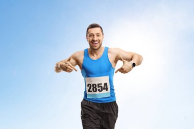 Mavi gökyüzüne karşı maraton koşan zinde bir genç.
