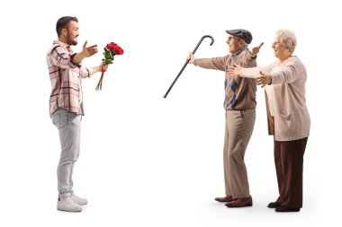 Full length profile shot of a young man with red roses meeting elderly man and woman isolated on white background    