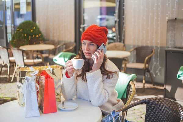 年轻美丽的黑发女子在咖啡店喝咖啡 并在网上购买圣诞礼物 — 图库照片