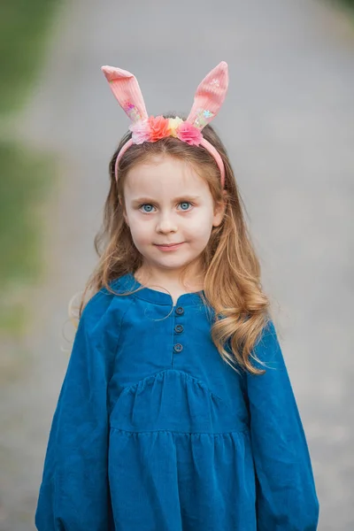 イースターだ 桜の花の中にウサギの耳を持つ長い巻き毛のかわいい女の子 — ストック写真