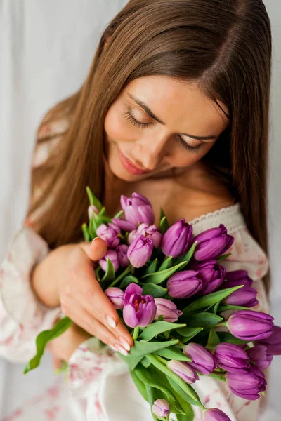 长发的年轻女子的画像 模型与一束紫丁香郁金香白色 — 图库照片