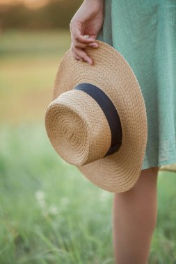 Gün batımında genç ve güzel bir Asyalı kadın sahada. Uzun kıvırcık saçlı bir model. Yaz, güneş.