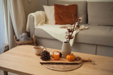 Sonbahar dekoru. Sıcak içecek. Bir kupa çay, kitap, balkabağı, ahşap sehpadaki mum. Sonbahar. Düş.