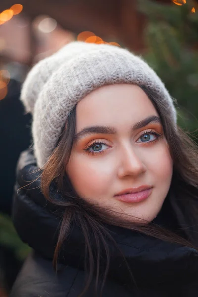 Beautiful young woman with dark hair happy at a European Christmas market. Holidays. New Year.