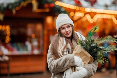 Almanya 'daki Noel pazarında Avrupalı genç ve mutlu bir kadın. Şenlikli şehir. Dekorasyon. Yeni Yıl.