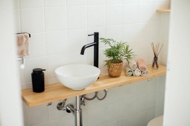 Tuvalet siyah-beyaz. Ev dekoru. Lavabo, el havluları, dağıtıcı, ev çiçeği..