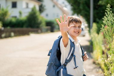 Okula dönelim. Sırt çantalı şirin, mutlu çocuk evden okula gidiyor. Samimi.