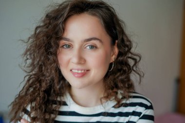 Evdeki genç, mutlu, kıvırcık kadının portresi..