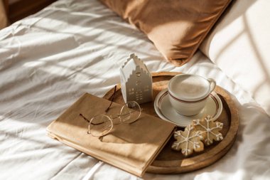 Noel sıcacık ev dekorasyonu. Kurabiyeler, ahşap tepside bir fincan kapuçino. Kahvaltı..