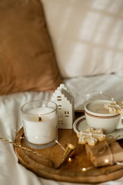 Noel sıcacık ev dekorasyonu. Kurabiyeler, ahşap tepside bir fincan kapuçino. Kahvaltı..