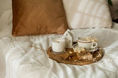 Noel sıcacık ev dekorasyonu. Kurabiyeler, ahşap tepside bir fincan kapuçino. Kahvaltı..