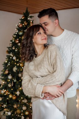 Aile Noel ağacının yanında oturuyor ve hediyeleri açıyor. Kış tatili Tatiller