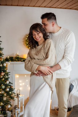 Aile Noel ağacının yanında oturuyor ve hediyeleri açıyor. Kış tatili Tatiller