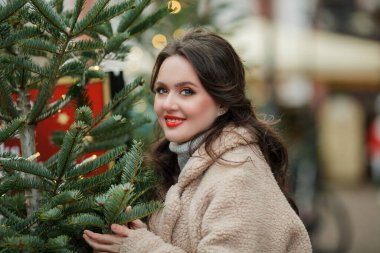 Avrupa 'daki Noel pazarında siyah saçlı güzel bir kadının portresi. Kış tatili Tatiller.