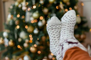 Evdeki Noel ağacının yanındaki çorapların içinde çocukların ayaklarına yakın çekim. Kış tatili.