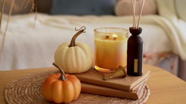 Balkabaklarıyla sıcacık bir sonbahar dekoru. Mum, dağıtıcı, sehpanın üzerindeki kitaplar..