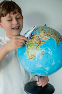 Küçük şirin çocuk elinde küçük bir uçakla dünyaya bakıyor. Yolculuk için rota hazırlanıyor. Ülke seçiliyor.