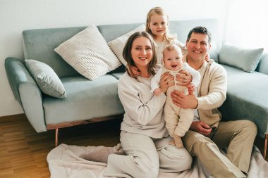 Evlerinde dinlenen küçük çocukları olan güzel, mutlu bir aile. Samimi.