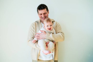 Yakın plan. Yakışıklı genç baba küçük oğluna sarılıyor. Samimi.