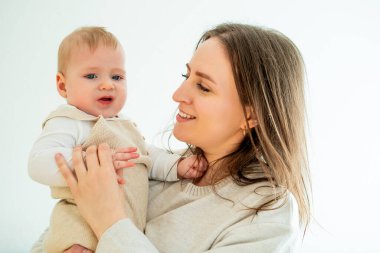 Mutlu anne, küçük oğlunu kollarında 9 ay kollarında tutuyor. Aile.