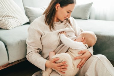 Mutlu anne evde kucağında bebeğini emziriyor. Helthy.