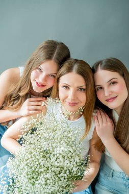 İki genç kız evde genç annelerine sarılıyorlar. Mutlu anne ve iki kız haberleşiyorlar. Bahar tatili. Aile değerleri.