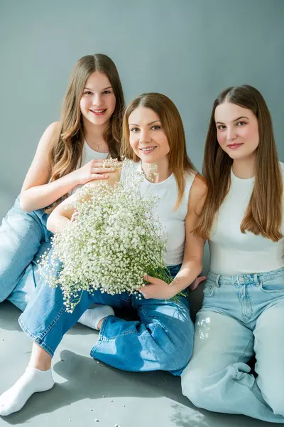 İki genç kız evde genç annelerine sarılıyorlar. Mutlu anne ve iki kız haberleşiyorlar. Bahar tatili. Aile değerleri.